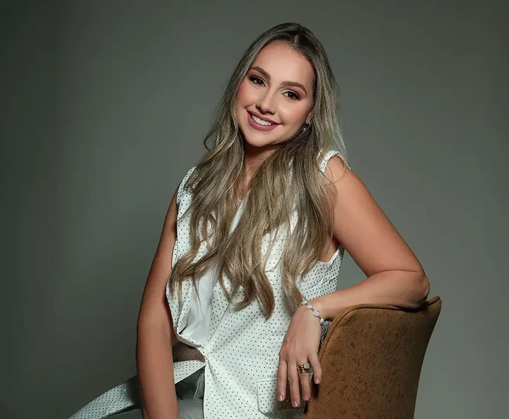 Dra. Suhellem Panciere sorrindo, com roupa clara